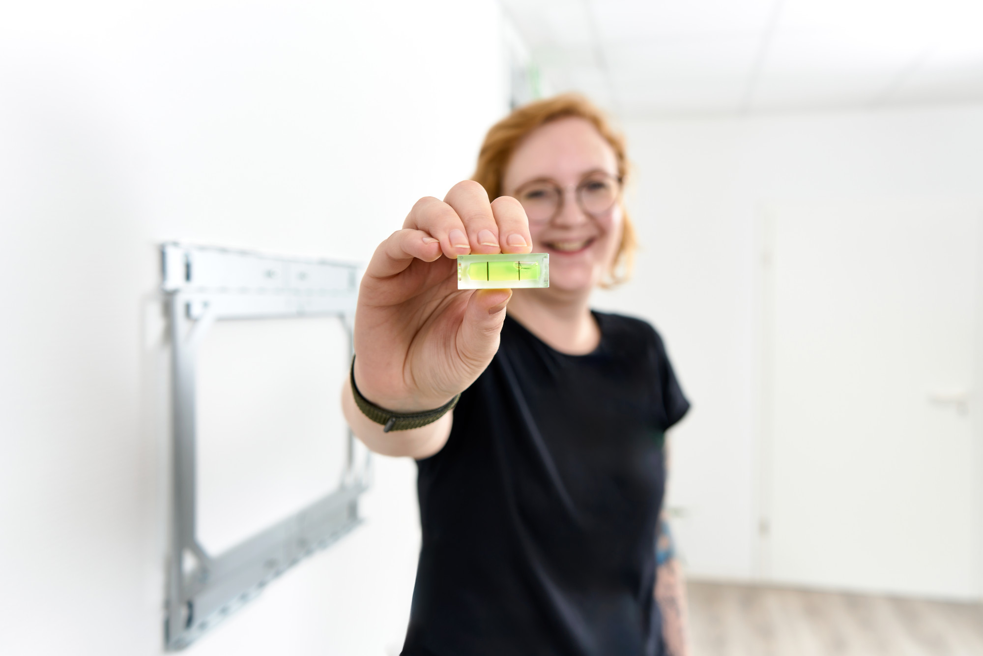 Kvinden viser vaterpasset, der er inkluderet i X-Rack-pakken. Kvinden viser vaterpasset, der er inkluderet i X-Rack-pakken.