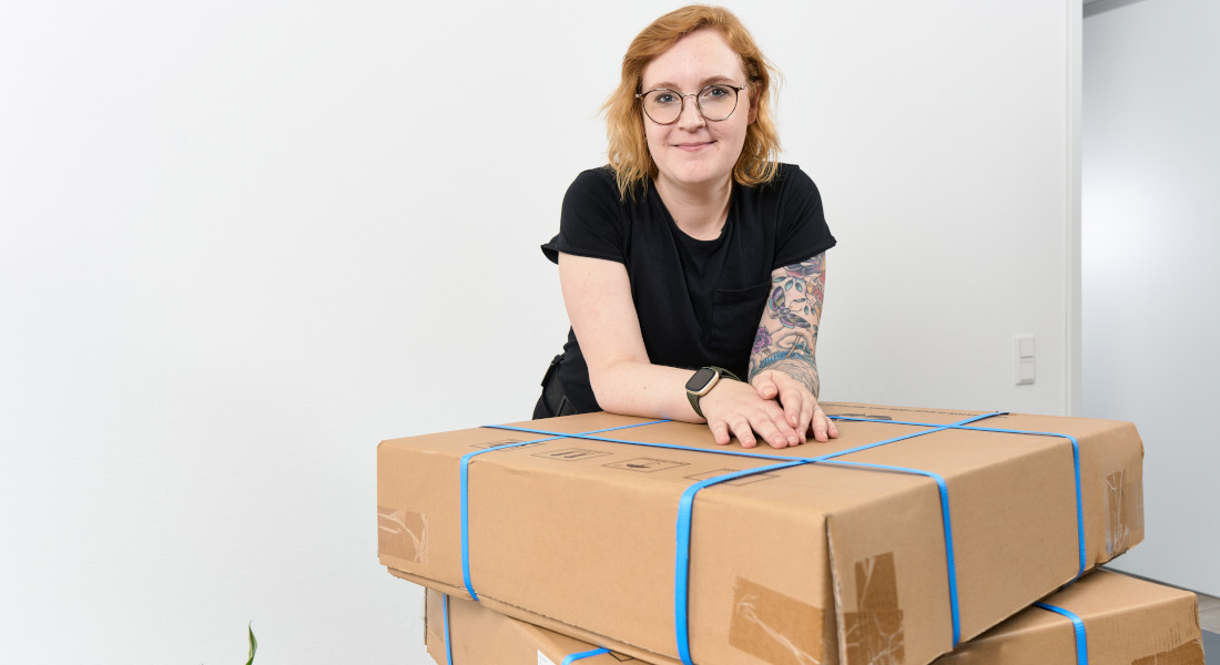 Kvinde læner sig op ad X-Rack-emballage Kvinde læner sig op ad X-Rack-emballage