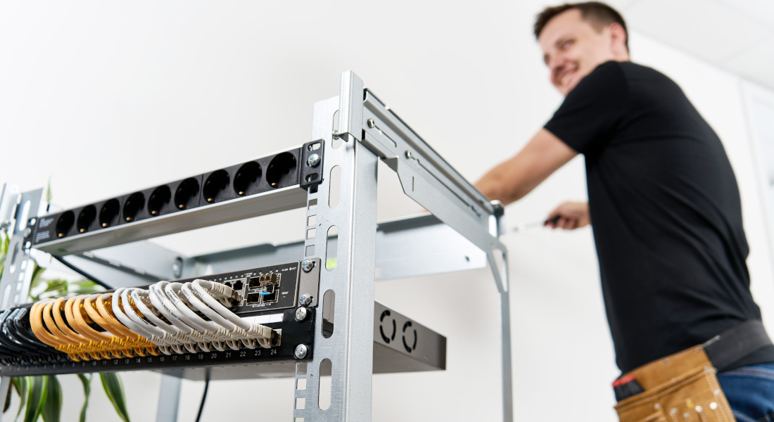 Mand strammer en skrue på X-Rack Mand strammer en skrue på X-Rack