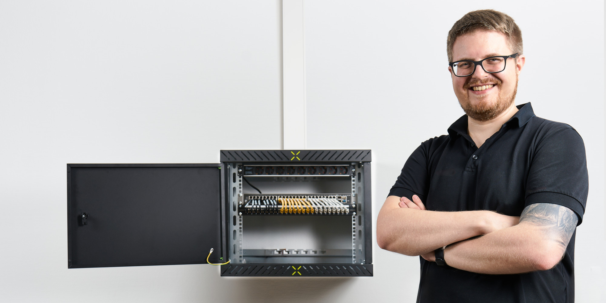 Mand poserer foran en færdigmonteret X-Rack med åben dør